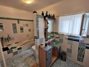 a bathroom with a tub and a sink and a toilet at Cantinho da Alice Family Villa in Sertã