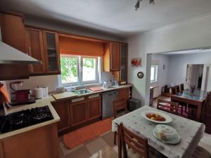 a kitchen with a table with a bowl of fruit on it at Cantinho da Alice Family Villa in Sertã