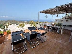 um pátio com cadeiras, uma mesa, uma mesa e uma vista em Apartment with a great terrace, sea and land views em Mojácar