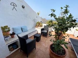 um pátio com uma mesa, cadeiras e vasos de plantas em Apartment with a great terrace, sea and land views em Mojácar