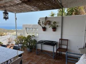 um pátio com uma mesa e cadeiras numa parede branca em Apartment with a great terrace, sea and land views em Mojácar