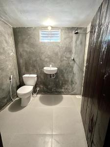 La salle de bains est pourvue de toilettes et d'un lavabo. dans l'établissement Lake House Homestay, à Anurâdhapura