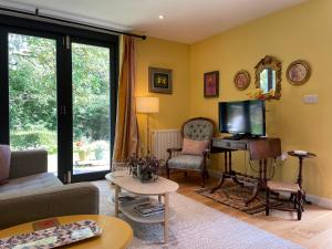 a living room with a couch and a tv at Garden hideaway, self-contained, edge of Bath in Bath