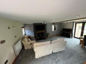 a living room with a couch and a television at The Cottage in Carlisle