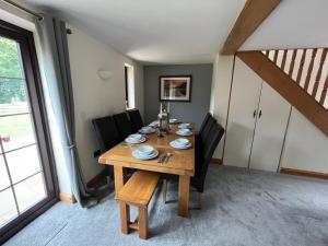 una sala da pranzo con tavolo in legno e sedie nere di The Cottage a Carlisle