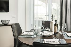 a dining room table with a bottle of wine and glasses at Privilegium Lazise in Lazise
