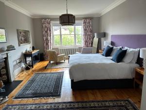 a bedroom with a king sized bed and a living room at The Knowle at St Leonards in St. Leonards