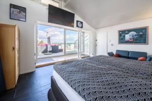a bedroom with a large bed and a large window at City Dream Seeblick free parking in Kreuzlingen
