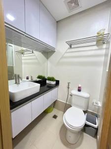 a white bathroom with a toilet and a sink at 2BR SMDC Trees w/Netflix&WIFI near the POOL. T65F in Manila