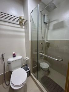 a bathroom with a toilet and a glass shower at 2BR SMDC Trees w/Netflix&WIFI near the POOL. T65F in Manila +18 photos