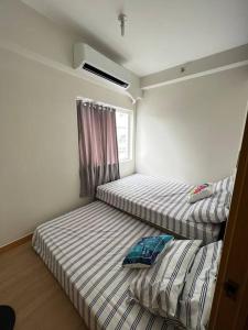 two twin beds in a room with a window at 2BR SMDC Trees w/Netflix&WIFI near the POOL. T65F in Manila
