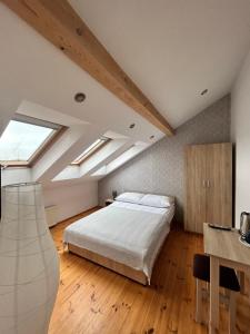 Schlafzimmer im Dachgeschoss mit einem Bett und einem Fenster in der Unterkunft Dom Gościnny 10tka Juliana in Łeba