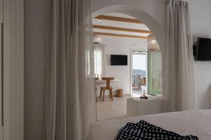a bedroom with a bed and a living room at Castello Amorgos Suites in Katapola