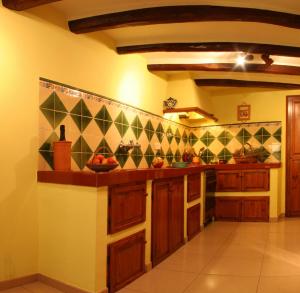 a kitchen with wooden cabinets and tiles on the wall at Cal Conrad in Nulles