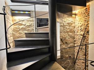 a spiral staircase in a room with a stone wall at Historical Luxury Homes - Luxus Familien Suite in Freiburg im Breisgau +52 photos