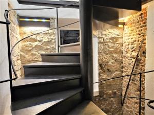 escalera de caracol en una habitación con pared de piedra en Historical Luxury Homes - Luxus Familien Suite, en Freiburg im Breisgau