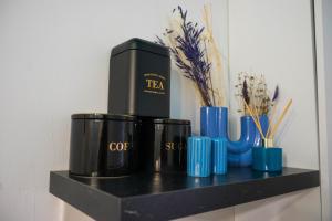 a shelf with two black coffee cups and blue vases at Porta Danube in Budapest