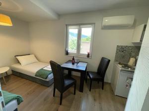 mały pokój z łóżkiem, stołem i krzesłami w obiekcie Apartments Enigma w mieście Mostar
