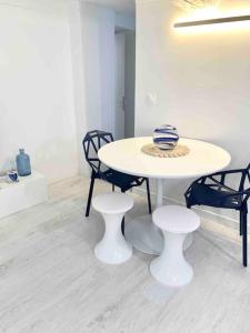 una mesa blanca y sillas con un jarrón. en Nouveau - Nice Mamac - centre en Niza