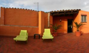 two chairs sitting on a brick patio next to a building at Cal Conrad in Nulles