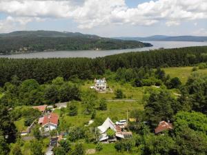 eine Luftansicht eines Hauses auf einem Hügel neben einem See in der Unterkunft Къща за гости Замък Никола in Shtarkelovo Gnezdo