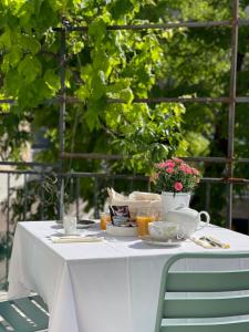 - une table blanche avec de la vaisselle et des fleurs dans l'établissement Maison Dormoy, à Marseille