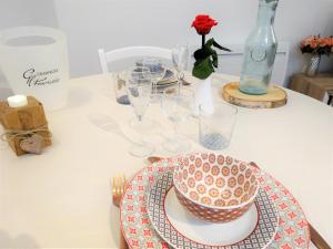 stół z talerzem i kieliszkami oraz wazonem w obiekcie Le Sablon - Hébergement bien-être, Spa & massages à 20mn de Reims centre w mieście Unchair