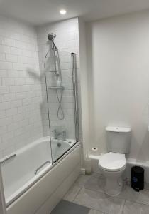 a bathroom with a tub and a toilet and a shower at 31 Galleria Court in London
