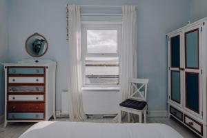 a bedroom with a bed and a window and a chair at Sligo Bay Lodge in Rosses Point