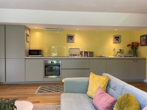 a living room with a couch and a kitchen at Garden hideaway, self-contained, edge of Bath in Bath