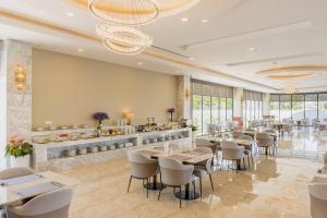a restaurant with tables and chairs in a room at Otres Beach Hotel in Sihanoukville