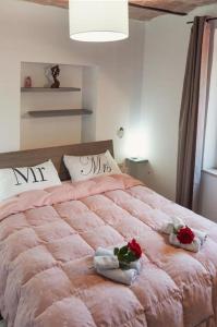 a bedroom with a large pink bed with towels and roses at Casa Vacanze Le Cascate in Le Marmore