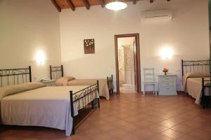 a bedroom with two beds and a dresser and a mirror at Lumia in Riposto