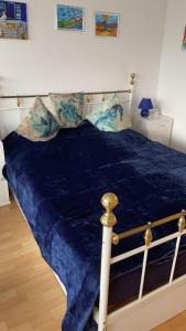 een bed met een blauw dekbed en kussens erop bij Haus-Crone in Burgtiefe auf Fehmarn 