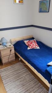 een slaapkamer met een bed met een blauwe deken en een tafel bij Haus-Crone in Burgtiefe auf Fehmarn 