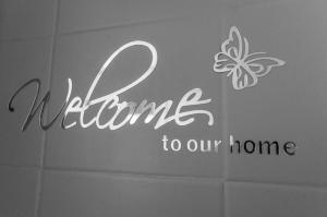 Znak z napisem "Witaj w naszym domu z motylem" w obiekcie Casa Vacanze Le Cascate w mieście Le Marmore