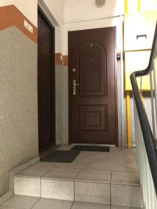 an empty hallway with a brown door and stairs at Apartament Zwirki i Wigury 38 in Bydgoszcz