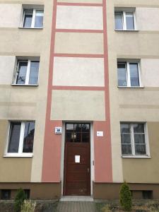 een gebouw met een bruine deur en ramen bij Apartament Zwirki i Wigury 38 in Bydgoszcz