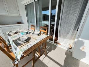 mesa de comedor con vistas a un balcón en Precioso apartamento con piscina, en Castelldefels