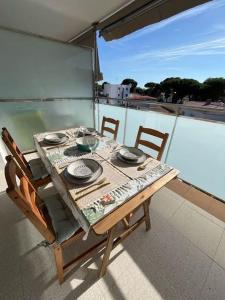 una mesa y sillas en un balcón con vistas al agua en Precioso apartamento con piscina, en Castelldefels