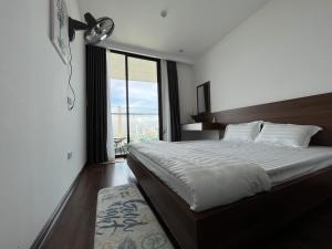 a bedroom with a large bed with a large window at 2S Ha Long Homestay in Ha Long