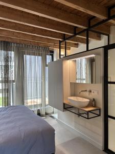 a bedroom with a bed and a sink and a mirror at De Eindhovenaar City Apartments in Eindhoven