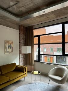 a living room with a couch and a large window at De Eindhovenaar City Apartments in Eindhoven