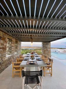 a dining room with a long table and chairs at Amalthea, Outstanding Seaside Luxury Villa, Paros in Santa Marina