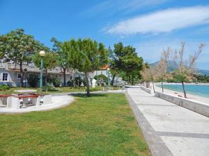 un parc à côté de l'eau avec des arbres et un trottoir dans l'établissement Apartments Pasalic, à Kaštela