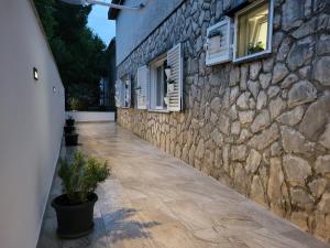 a stone wall with a walkway next to a building at Apartman Anabella in Rovanjska