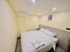 1 dormitorio con 1 cama blanca y 2 almohadas blancas en Nona Hotel, Bangkok en Makkasan