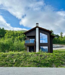 a small house on top of a grassy hill at Exclusive Penthouse Apartment with Sauna - 102 in Stranda