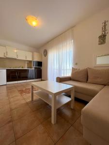 un soggiorno con un divano e un tavolo di Apartments Villa Klaudia - Adults Only a Crikvenica