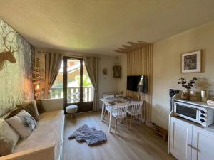 een woonkamer met een bank en een tafel bij Les marmottes in La Foux